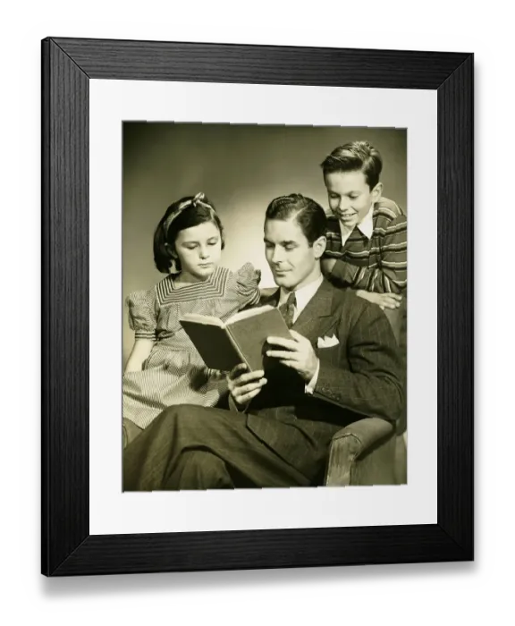 Framed Print : Father reading to son (4-5) and daughter ( 6-7) in studio, (B&W), portrait Framed Print : Father reading to son (4-5) and daughter ( 6-7) in studio, (B&W), portrait