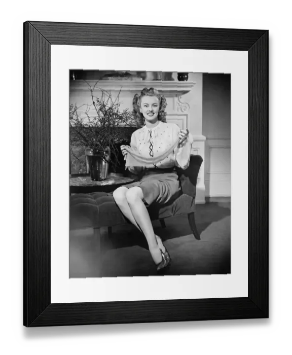 Framed Print : Woman sitting on chaise longue, holding scarf, (B&W), portrait Framed Print : Woman sitting on chaise longue, holding scarf, (B&W), portrait