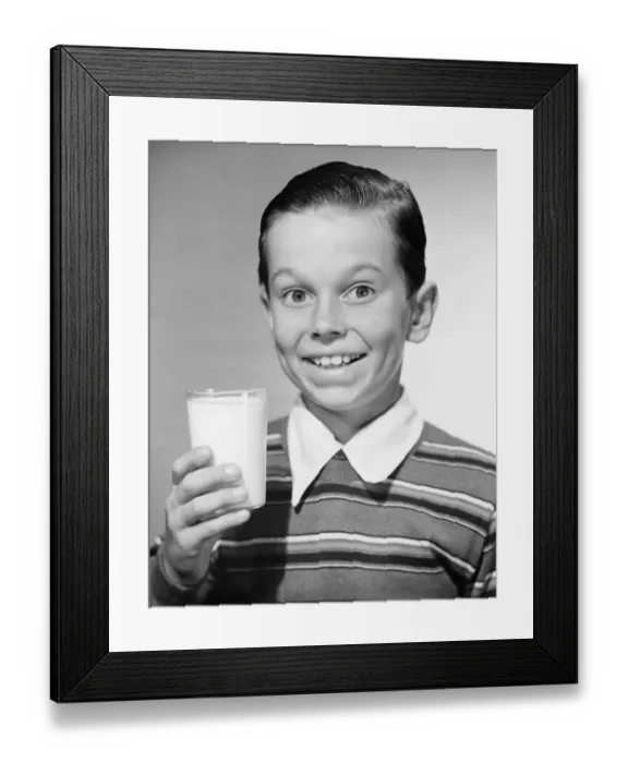 Framed Print : Boy (6-7) holding glass of milk, (B&W), portrait Framed Print : Boy (6-7) holding glass of milk, (B&W), portrait