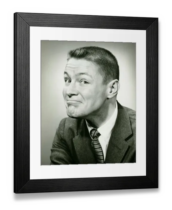 Framed Print : Man making face in studio, (B&W), close-up Framed Print : Man making face in studio, (B&W), close-up