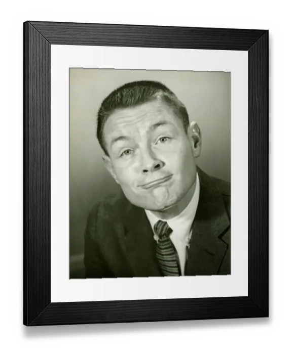 Framed Print : Man making face in studio, (B&W), close-up Framed Print : Man making face in studio, (B&W), close-up