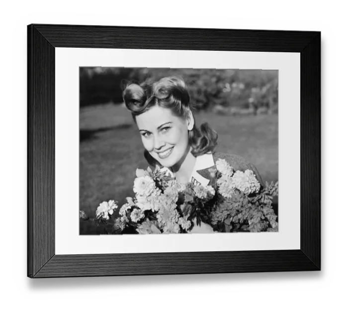 Framed Print : Woman in yard holding bunch of flowers, (B&W), portrait Framed Print : Woman in yard holding bunch of flowers, (B&W), portrait