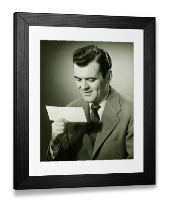 Framed Print : Smiling businessman looking at bank check, (B&W), portrait Framed Print : Smiling businessman looking at bank check, (B&W), portrait