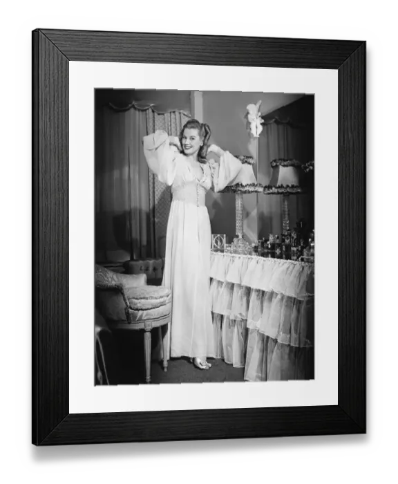 Framed Print : Woman posing by vanity table in opulent bedroom, (B&W), portrait Framed Print : Woman posing by vanity table in opulent bedroom, (B&W), portrait