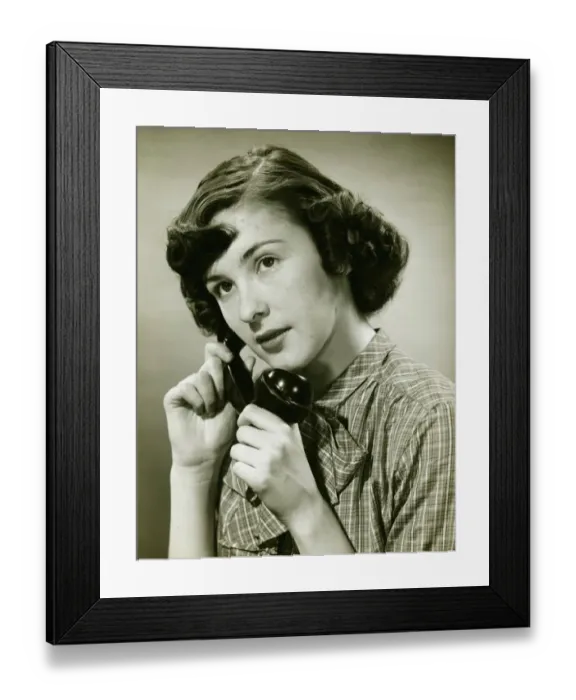Framed Print : Teenage girl (16-17) on phone posing in studio, (B&W), portrait Framed Print : Teenage girl (16-17) on phone posing in studio, (B&W), portrait