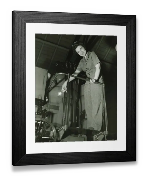 Framed Print : Woman operating machine in factory, (B&W), portrait, low angle view Framed Print : Woman operating machine in factory, (B&W), portrait, low angle view