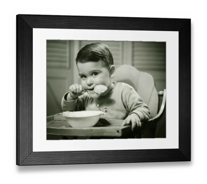 Framed Print : Boy (4-5) sitting in high chair, eating porridge, (B&W), portrait Framed Print : Boy (4-5) sitting in high chair, eating porridge, (B&W), portrait