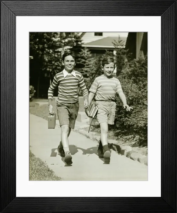 Framed Print : Two boys (10-11) walking side by side in suburbs, carrying books, (B&W) Framed Print : Two boys (10-11) walking side by side in suburbs, carrying books, (B&W)