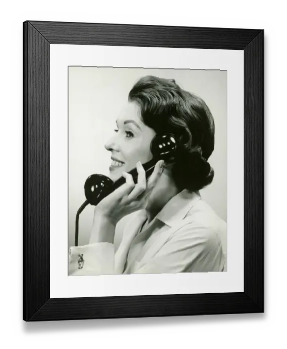 Framed Print : Woman using phone, posing in studio, (B&W), (Close-up) Framed Print : Woman using phone, posing in studio, (B&W), (Close-up)