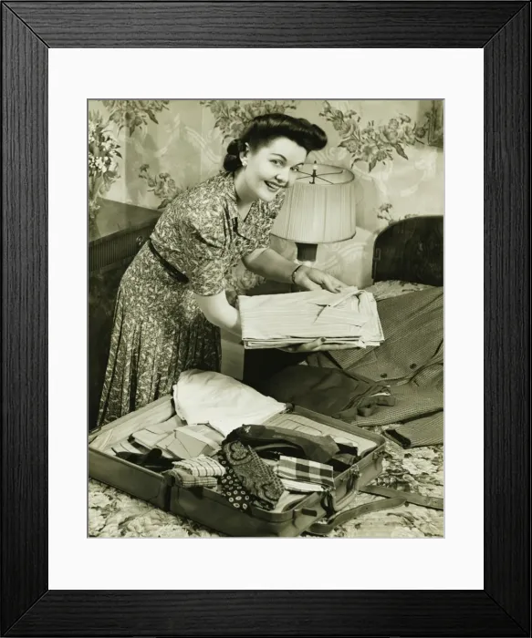 Framed Print : Woman putting clothes into suitcase, (B&W) Framed Print : Woman putting clothes into suitcase, (B&W)
