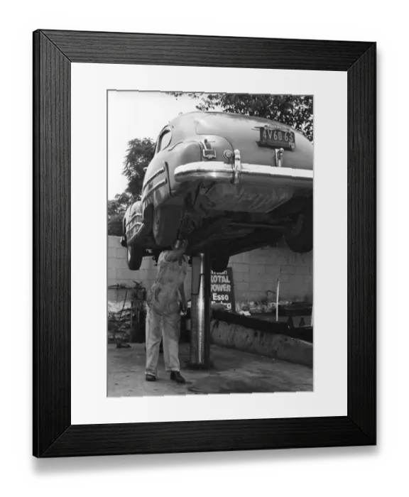 Framed Print : Mechanic working on underside of car Framed Print : Mechanic working on underside of car