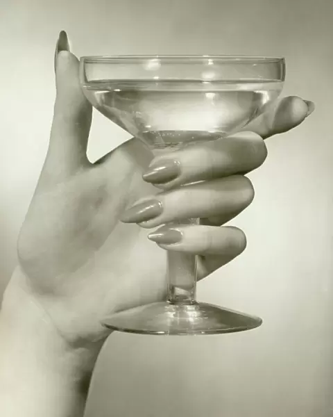 Womans hand holding martini, close-up