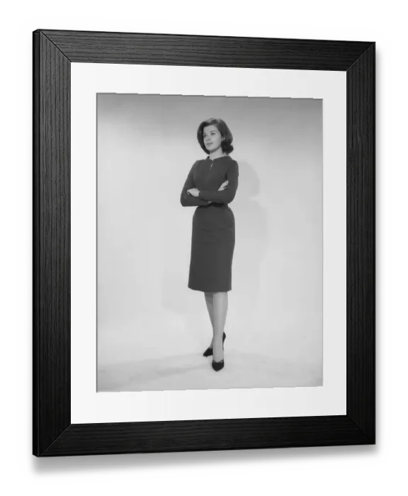 Framed Print : Woman standing with arms crossed, studio shot Framed Print : Woman standing with arms crossed, studio shot