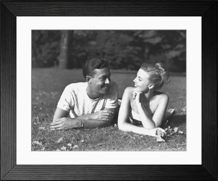 Framed Print : Young couple lying on lawn, (B&W)