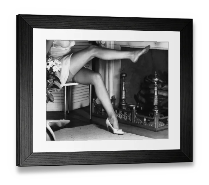 Framed Print : Woman wearing stockings sitting by fireplace, (B&W), low section Framed Print : Woman wearing stockings sitting by fireplace, (B&W), low section