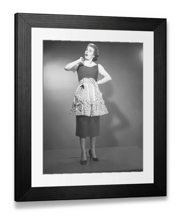 Framed Print : Woman in apron posing in studio, (B&W), , portrait Framed Print : Woman in apron posing in studio, (B&W), , portrait
