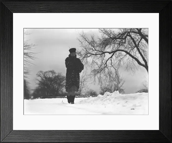 Framed Print : Woman walking on snow covered road, (B&W), low angle view Framed Print : Woman walking on snow covered road, (B&W), low angle view