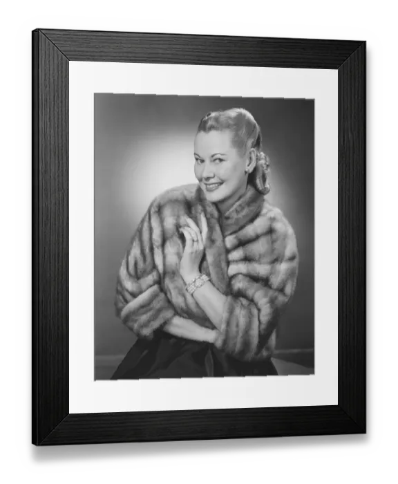 Framed Print : Woman wearing fur jacket posing in studio (B&W), portrait Framed Print : Woman wearing fur jacket posing in studio (B&W), portrait