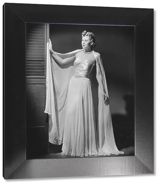 Woman in evening gown posing in studio (B&W), portrait