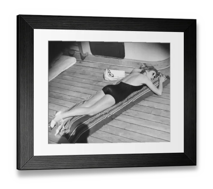 Framed Print : Young woman sun tanning on cruiser deck (B&W), elevated view Framed Print : Young woman sun tanning on cruiser deck (B&W), elevated view