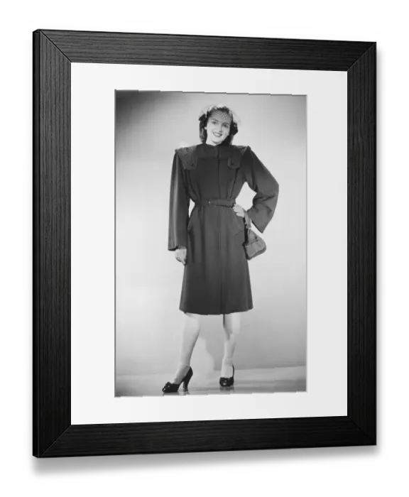 Framed Print : Woman in overcoat posing in studio (B&W), portrait Framed Print : Woman in overcoat posing in studio (B&W), portrait