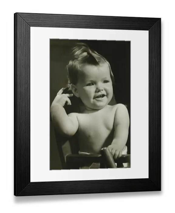 Framed Print : Baby boy (6-9 months) sitting in high chair, (B&W), portrait Framed Print : Baby boy (6-9 months) sitting in high chair, (B&W), portrait