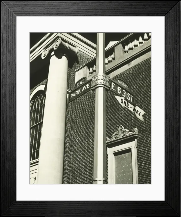 Framed Print : Directional sign and part of building, low angle view (B&W) Framed Print : Directional sign and part of building, low angle view (B&W)
