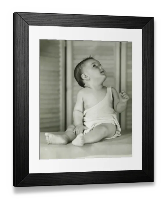 Framed Print : Baby boy (6-12) sitting on floor indoors, looking upwards, (B&W) Framed Print : Baby boy (6-12) sitting on floor indoors, looking upwards, (B&W)