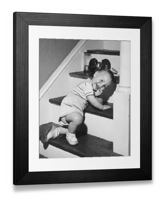Framed Print : Boy (18-24 months) kneeling on steps, smiling, (B&W)