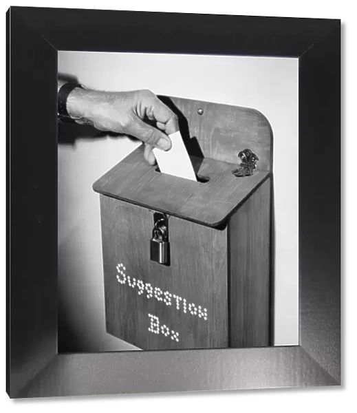 Hand dropping note in suggestion box