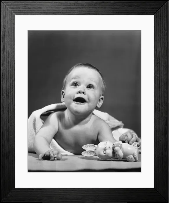 Framed Print : Baby wrapped in blanket, holding toy rabbit Framed Print : Baby wrapped in blanket, holding toy rabbit