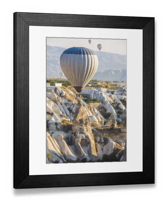 Framed Print : Hot air balloon flying over rock landscape at Cappadocia Turkey