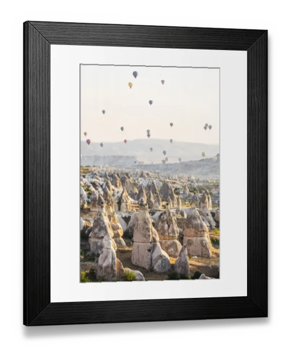 Framed Print : Hot air balloon flying over rock landscape at Cappadocia Turkey