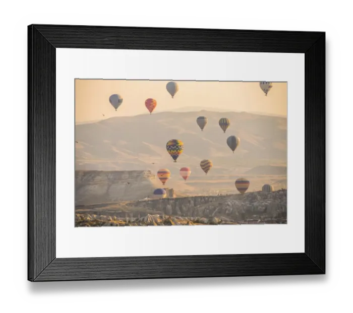 Framed Print : Hot air balloon flying over rock landscape at Cappadocia Turkey