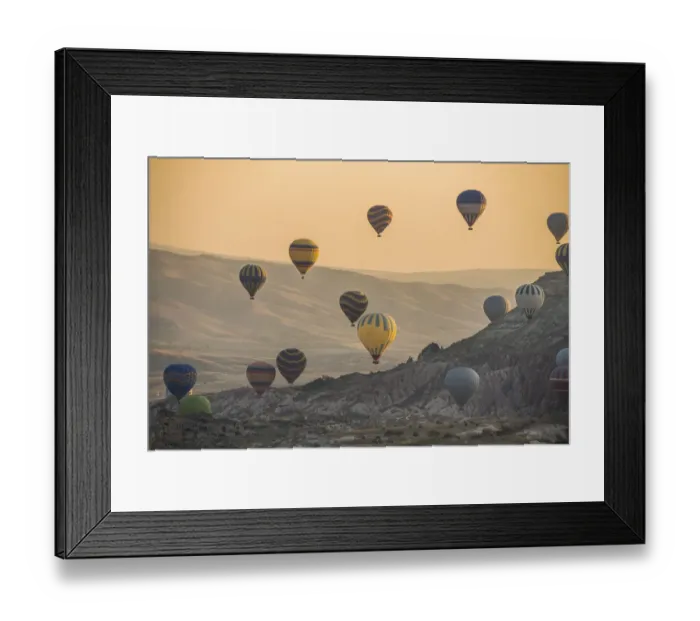 Framed Print : Hot air balloon flying over rock landscape at Cappadocia Turkey