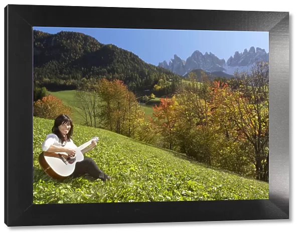 Woman playing guitar in the mountains