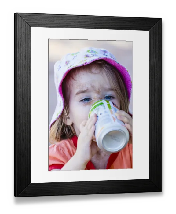 Framed Print : Girl, two years, face caked in sand, drinking from beverage can, Namibia Framed Print : Girl, two years, face caked in sand, drinking from beverage can, Namibia