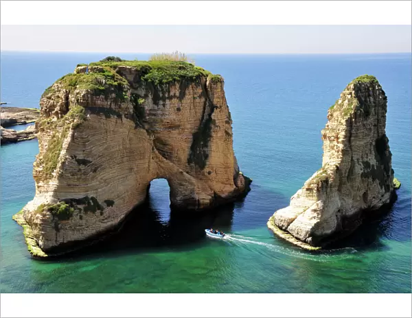 Excursion boat off the Pigeons Rock, Grotte aux Pigeons, limestone rocks eroded by wind and weather in the Raouche district, Beirut, Lebanon, Middle East, Asia