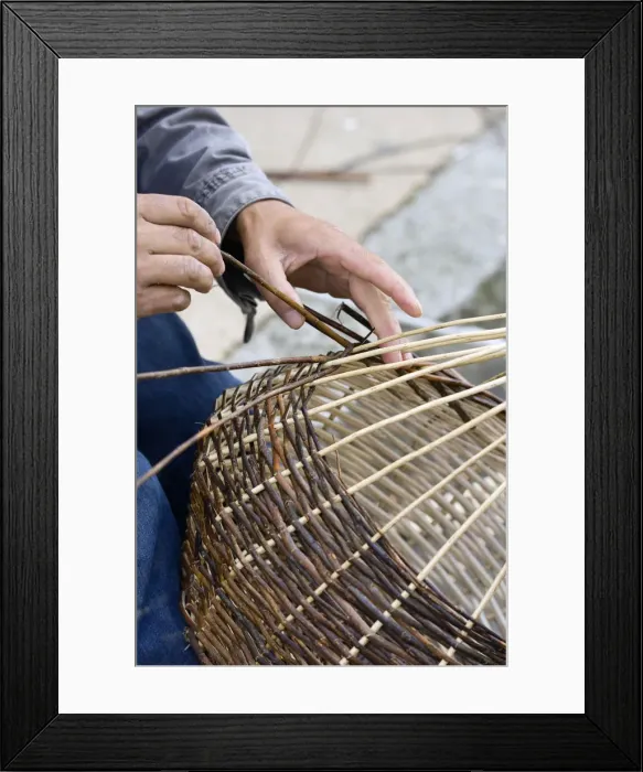 Framed Print : A basket weaver sitting on the street and weaving a basket, Brittany, France, Europe Framed Print : A basket weaver sitting on the street and weaving a basket, Brittany, France, Europe