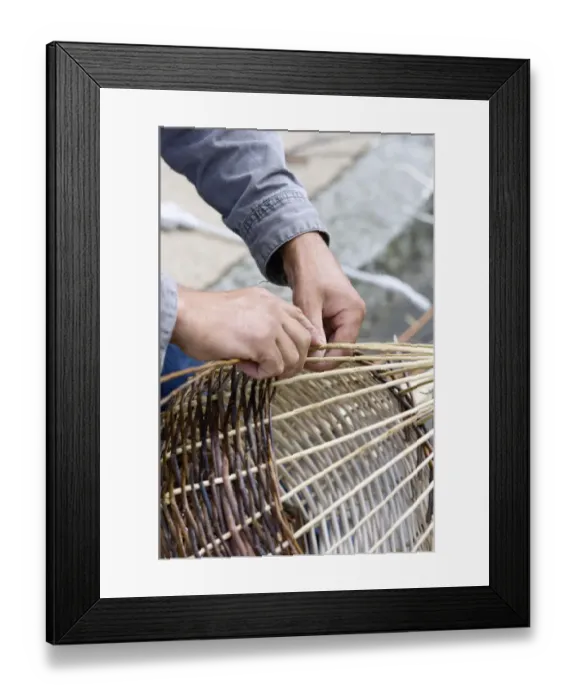 Framed Print : A basket weaver sitting on the street and weaving a basket, Brittany, France, Europe Framed Print : A basket weaver sitting on the street and weaving a basket, Brittany, France, Europe