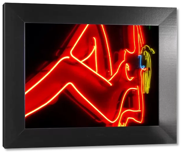 Neon sign in a red light district, nude female