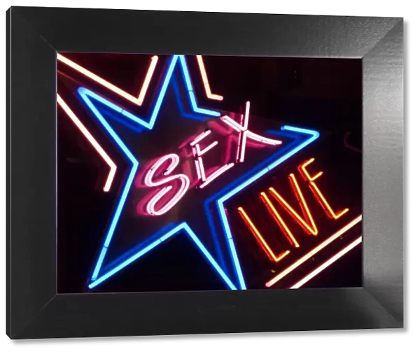 Neon sign in a red light district, with the lettering Sex Live