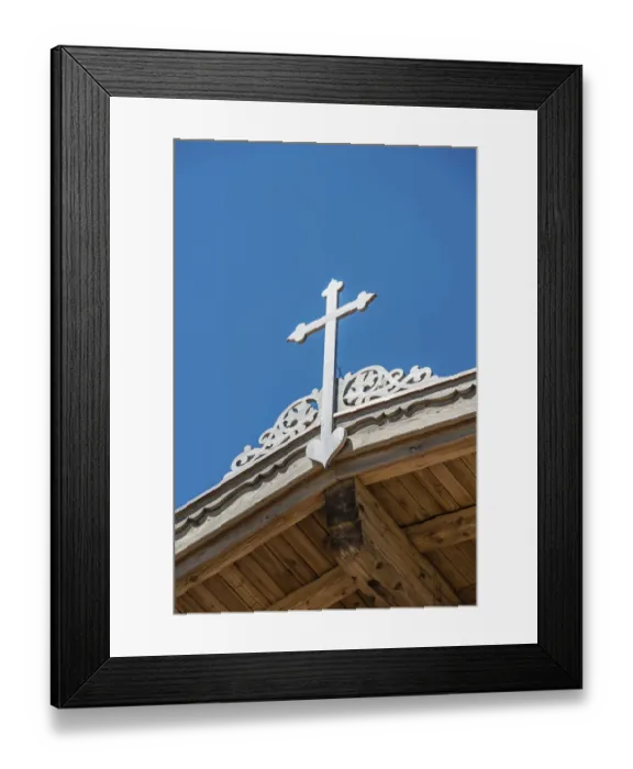 Framed Print : Crucifix on a wooden roof against a blue sky