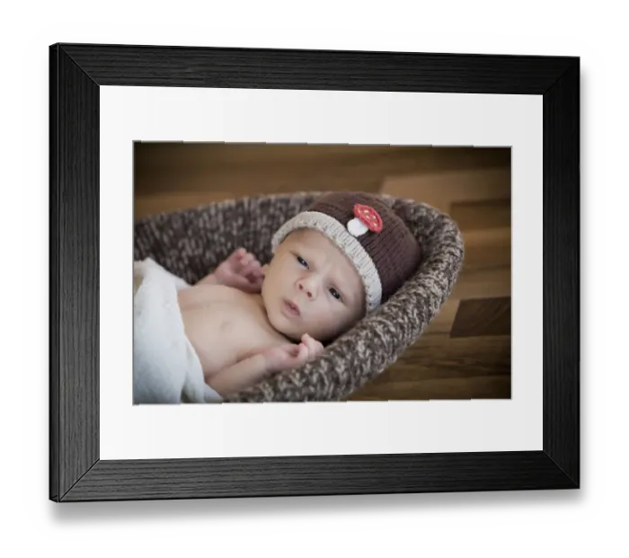Framed Print : Newborn baby, 3 weeks, wearing a hat, lying in a basket Framed Print : Newborn baby, 3 weeks, wearing a hat, lying in a basket