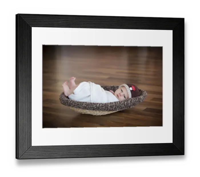 Framed Print : Newborn baby, 3 weeks, wearing a hat, lying in a basket