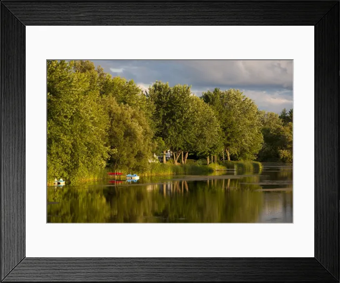Framed Print : Trees and boats on Yamaska River in evening light with threatening clouds, Waterloo, Eastern Townships, Quebec Province, Canada Framed Print : Trees and boats on Yamaska River in evening light with threatening clouds, Waterloo, Eastern Townships, Quebec Province, Canada