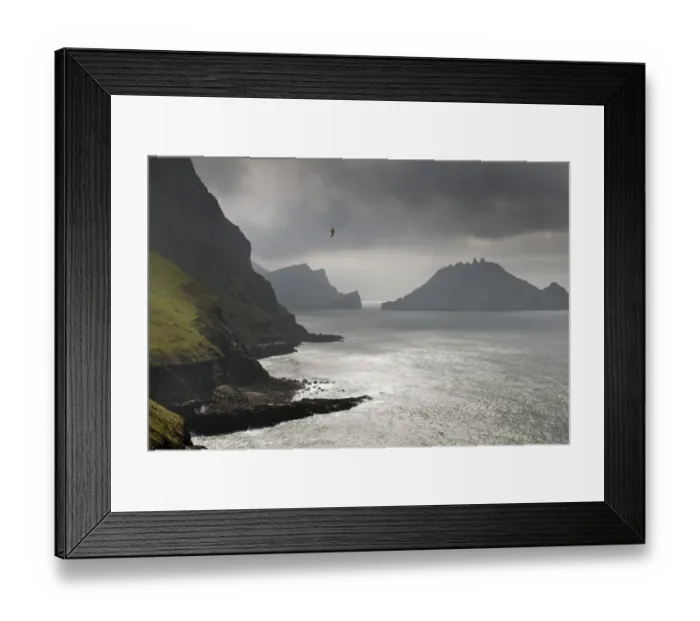 Framed Print : Cliffs in front of the silhouette of the rugged rocks of Tindholmur, Vagar, Faroe Islands, Denmark Framed Print : Cliffs in front of the silhouette of the rugged rocks of Tindholmur, Vagar, Faroe Islands, Denmark