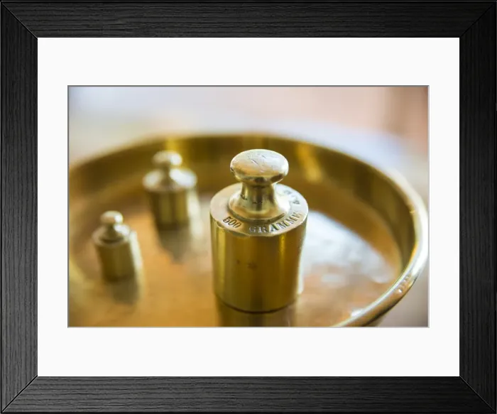 Framed Print : Weights on a golden weighing scale Framed Print : Weights on a golden weighing scale