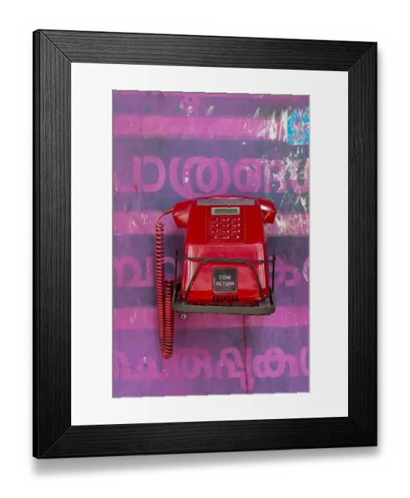 Framed Print : Old red telephone against a wall with pink Malayalam script, Kerala, India Framed Print : Old red telephone against a wall with pink Malayalam script, Kerala, India