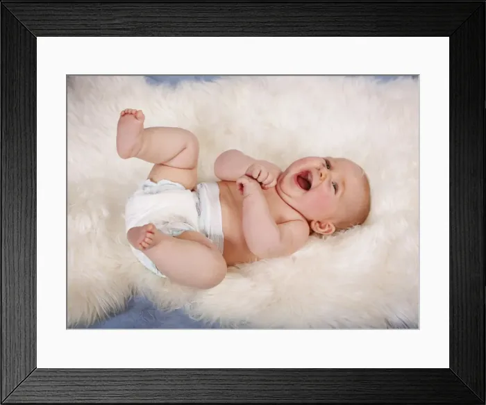 Framed Print : Baby, 5 months, lying on his back, on sheepskin rug, laughing, Germany